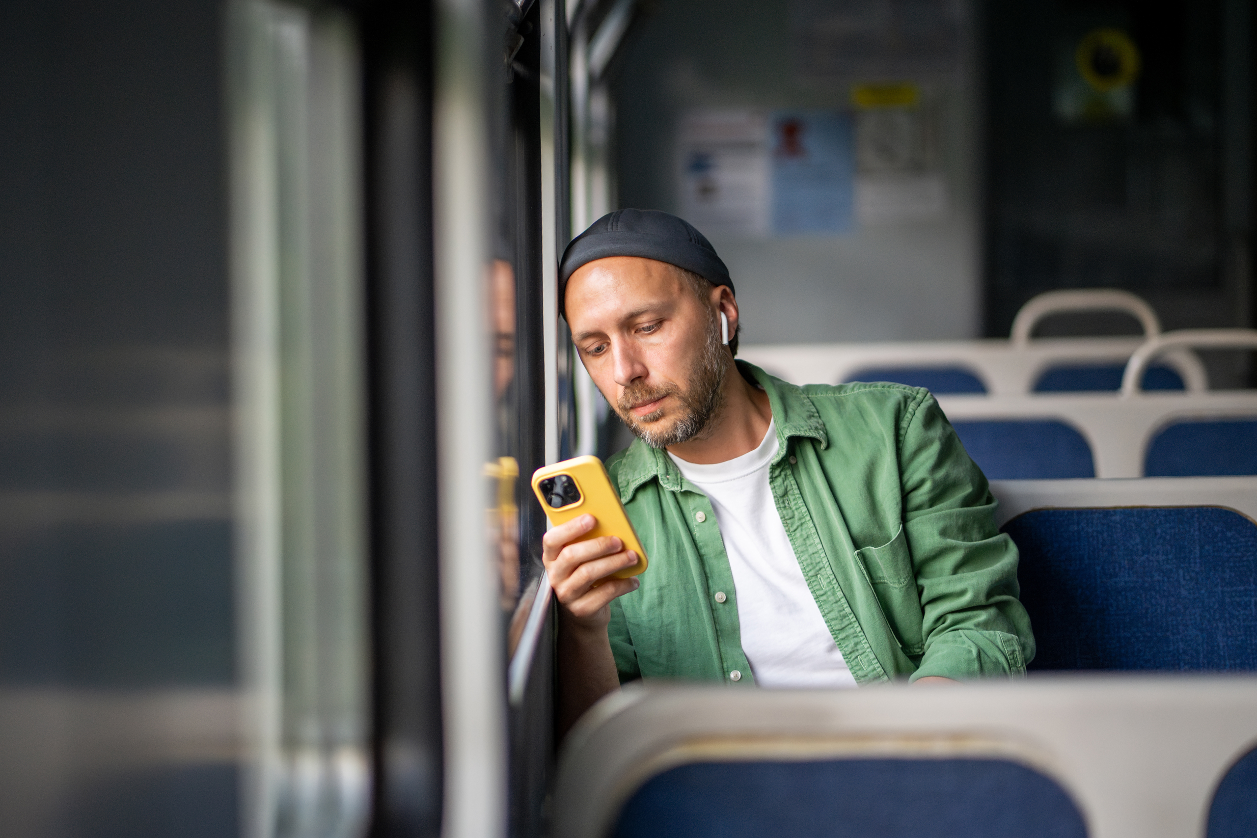 A man checking ADHD tracking data on his phone during commute.